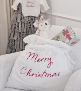 a Cream Faux Fur 'Merry Christmas' Sack displayed with a selection of toys.