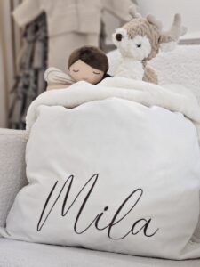 a Cream Velvet & Faux Fur Personalised Sack displayed with a selection of toys
