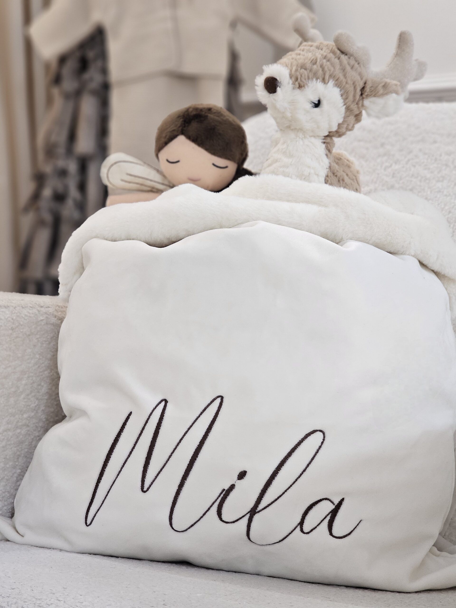 a Cream Velvet & Faux Fur Personalised Sack displayed with a selection of toys