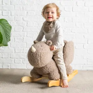 toddler playing on the Nattou Rocking Teddy Rhino in taupe