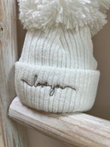 close up of Love You embroidery on The Baby Store Love You wool pom hat