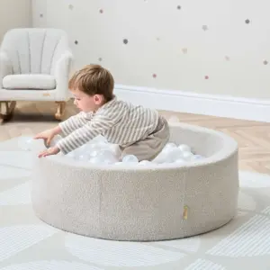 toddler playing in the Tutti Bambini Bola Baby Ball Pit in Mushroom