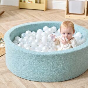 baby playing in the Tutti Bambini Bola Baby Ball Pit in Ocean Stone