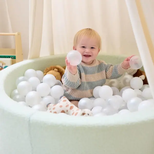 baby playing in the Tutti Bambini Bola Baby Ball Pit in sea foam