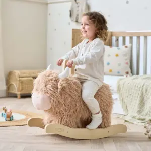 toddler playing on the Tutti Bambini Douglas the Highland Cow rocking toy