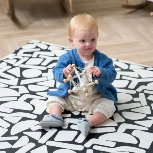 baby playing on the Tutti Bambini Infinity Baby Playmat in Oddity Mono