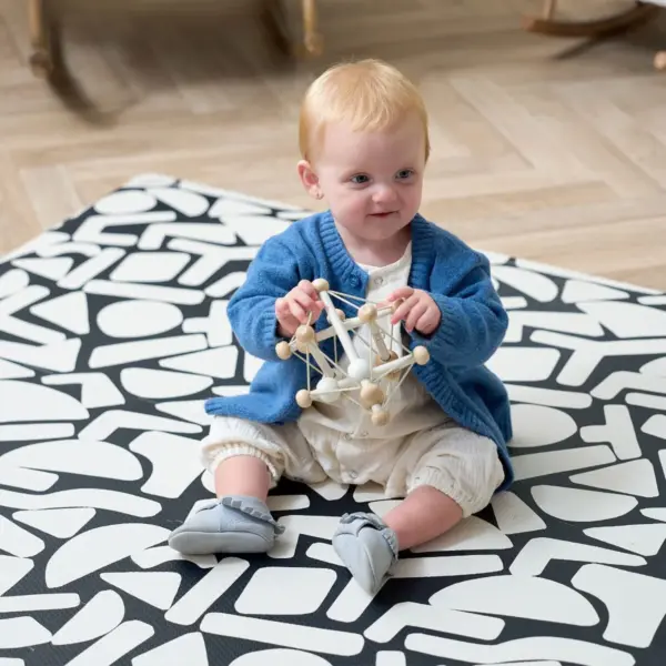 baby playing on the Tutti Bambini Infinity Baby Playmat in Oddity Mono