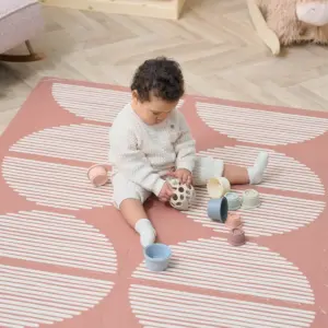 toddler playing on the Tutti Bambini Infinity Playmat in Orbital Nutmeg design