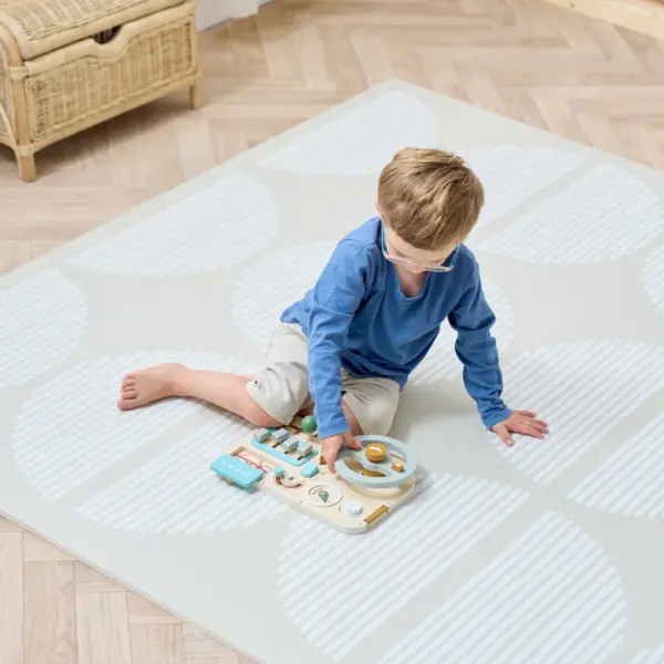 child playing on the Tutti Bambini Infinity Baby Playmat in Orbital Oatmeal
