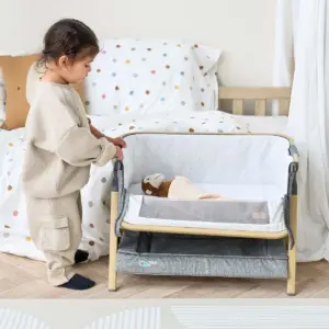 Toddler playing with the Tutti Bambini CoZee Mini Me Play Crib - Oak/Charcoal