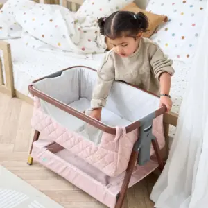 Toddler playing with the Tutti Bambini CoZee Luxe Mini Me Crib in Walnut and Blush