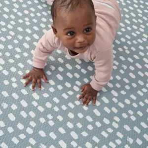 Baby crawling on Dash side of Tutti Bambini XL Reversible Playmat in Cathedral & Dash