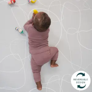 baby playing on the reverse side of the Tutti Bambini Luxury Padded XL Reversible Play Mat
