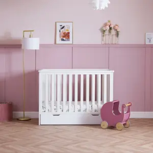 the Obaby Evie Mini Under Drawer in white shown with the Evie Mini Cot in a pink nursery room setting