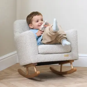 Young child sitting on the Tutti Bambini Jonah Mini Me Children's Rocking Chair in boucle mushroom